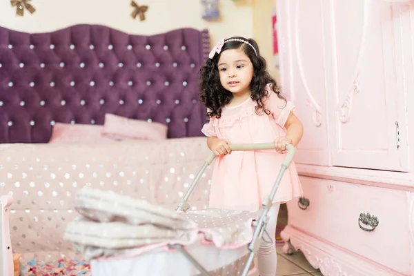 在她的粉红色卧室里推婴儿推车的婴儿宝宝 — 图库照片