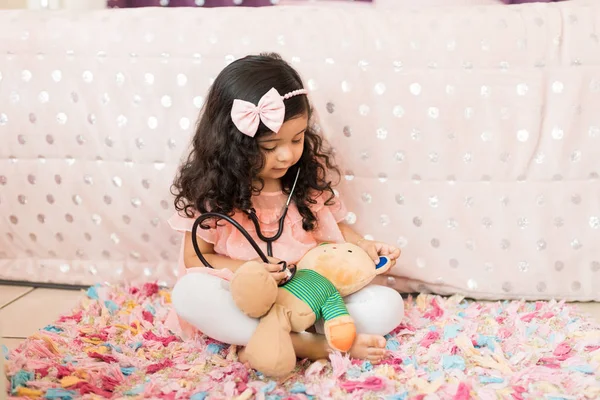 Vrouwelijke Kind Doen Behandeling Van Teddybeer Met Stethoscoop Slaapkamer — Stockfoto