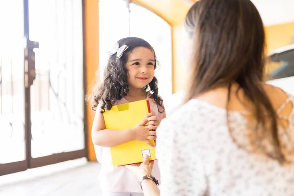 Petite Fille Mignonne Tenant Des Livres Tout Regardant Jeune Mère — Photo