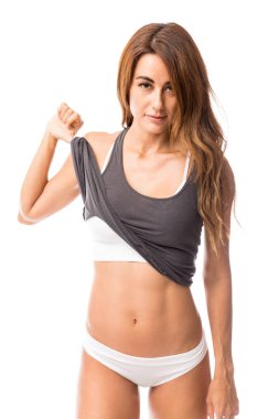 Kadın spor hocası tanktop kadar beyaz arka plan düz karın gösteriş yapmak için malzeme çekme portresi