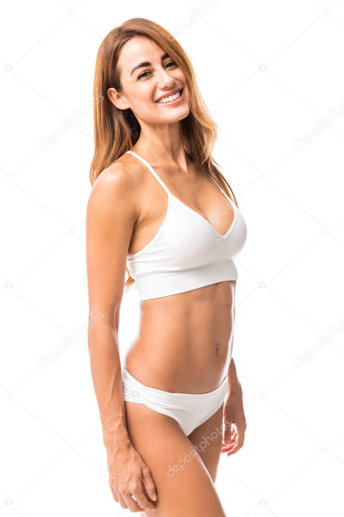 Attractive woman in sexy lingerie smiling while standing in studio