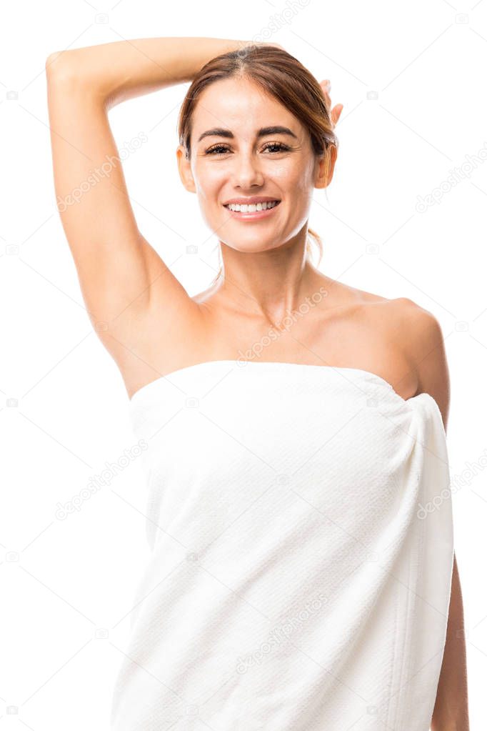 Attractive and happy woman showing her clean underarm against white background