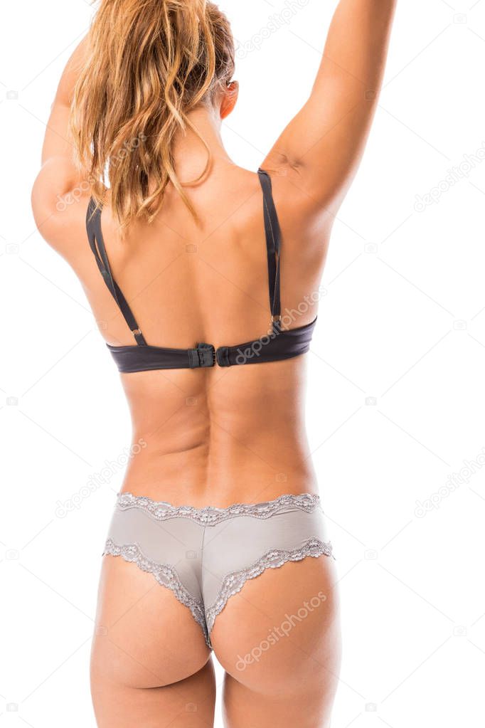 Rear view of mid adult woman wearing sexy lingerie while standing against white background