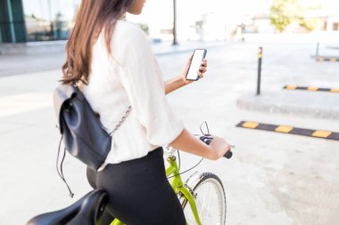 Midsection İspanyol kadın profesyonel döngüsü Caddesi üzerinde sürme sırasında Gps kullanarak