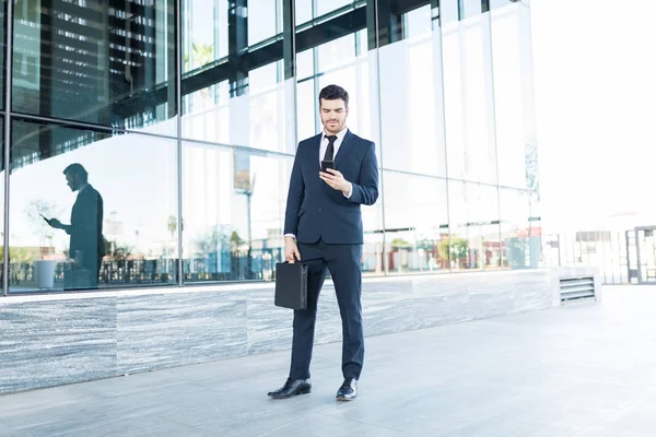 Joven Guapo Usando Traje Mientras Usa Teléfono Inteligente Pasarela Ciudad — Foto de Stock