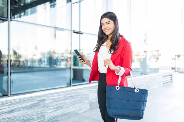 Porträtt Ganska Ung Affärskvinna Hålla Smartphone Och Handväska Medan Promenader — Stockfoto