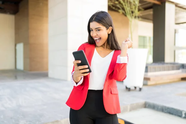 Pretty Businesswoman Wearing Red Jacket While Reading Positive News Smartphone — Stock Photo, Image