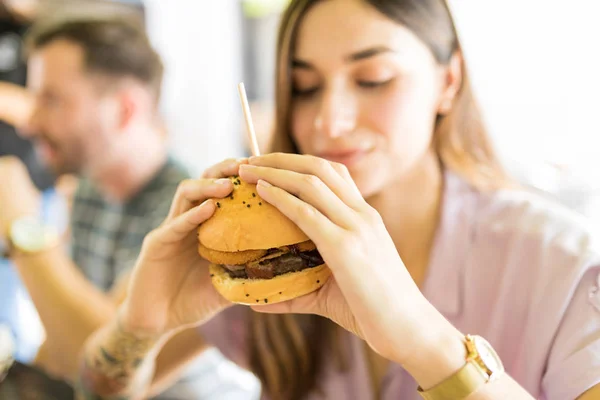 Νεαρή Γυναίκα Τρώει Φρέσκα Cheeseburger Στο Εστιατόριο — Φωτογραφία Αρχείου