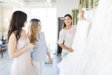 Düğün için güzel bir elbise seçiminde heyecanlı kadın alıcılar