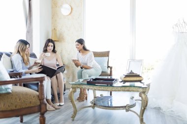 Genç çok ırklı kadın gelinlik dükkanında kataloğu için arıyor