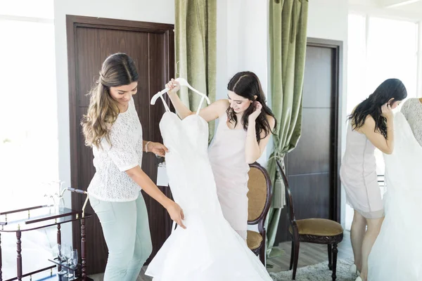 Female best friends admiring wedding outfit at bridal shop
