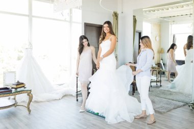 Onu gelin deposunda yardımcı arkadaş süre zarif bir gelinlik giyen memnun İspanyol gelin