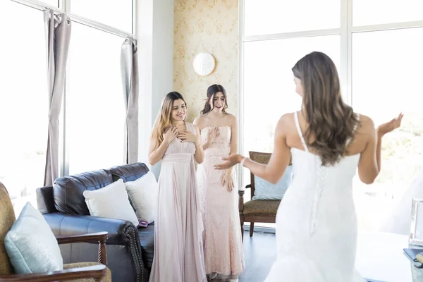 Überrascht Brautjungfern Betrachten Schöne Braut Brautkleid Wohnzimmer — Stockfoto