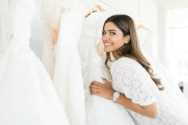 Красивая Женщина Улыбается Выбирая Белое Свадебное Платье Бутике — стоковое фото