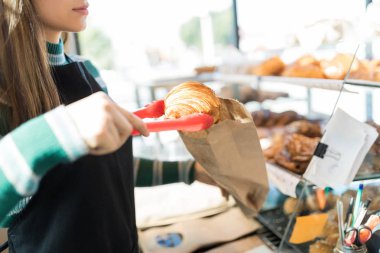 Taze pişmiş kruvasan ambalaj mağazada kadın baker midsection