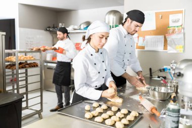 Mutfakta erkek iş arkadaşınız ile çalışırken hamur topları yapma kadın pastacı