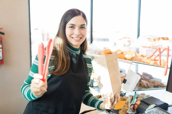 Porträtt Glad Försäljare Håller Papperspåse Och Tång Bageri — Stockfoto