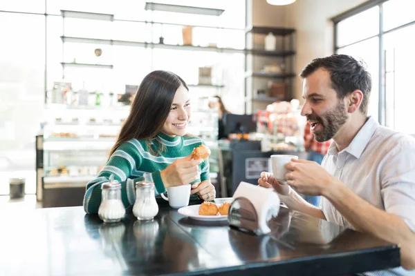 パン屋さんで日付を楽しみながらコーヒーと Chouxs を持つ夫婦 — ストック写真