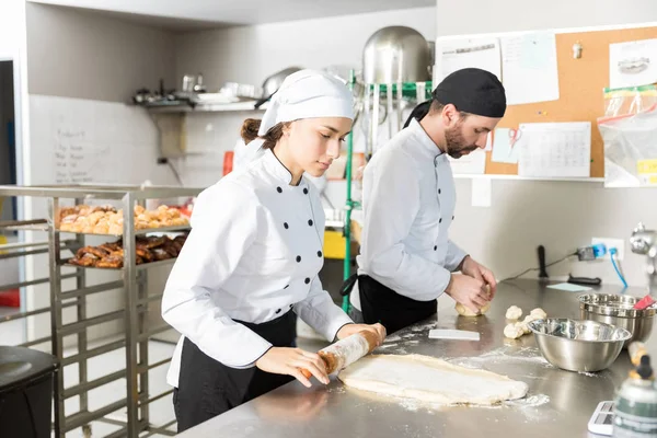 Chef Feminino Massa Rolante Enquanto Trabalhava Com Colega Padaria — Fotografia de Stock
