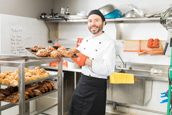プロのキッチンでおいしいお菓子を示す大人の腕利きのシェフ — ストック写真