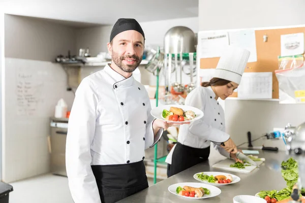 Chef Adulto Medio Seguro Sosteniendo Plato Pollo Verduras Cocina — Foto de Stock