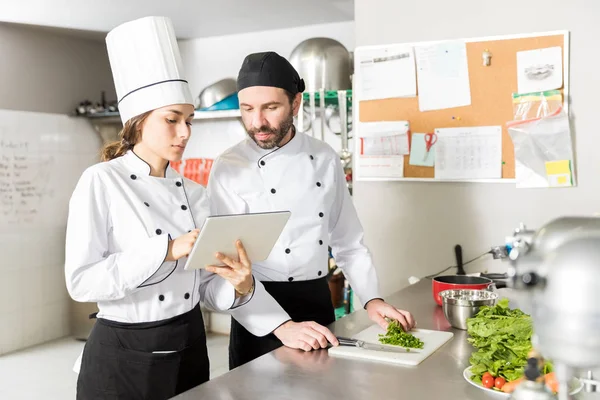Chefs Masculinos Femininos Lendo Receitas Tablet Digital Cozinha — Fotografia de Stock