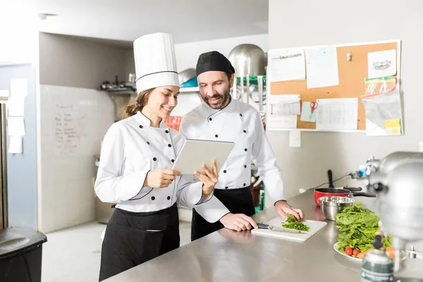 Chef Feminino Sorrindo Enquanto Compartilha Tablet Computador Com Colega Cozinha — Fotografia de Stock