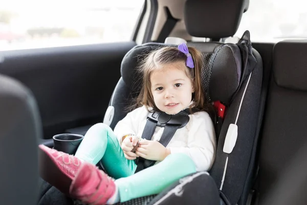 公路旅行中坐在车上安全座椅上的学龄前女孩全长画像 — 图库照片