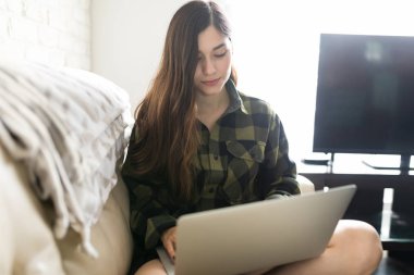 Oturma odasında kablosuz teknoloji kullanarak uzun saçlı çekici kadın