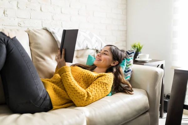 Wanita Muda Membaca Novel Lucu Sambil Berbaring Sofa — Stok Foto