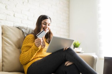 Sevimli genç kadın onu banka kartı ve tablet bilgisayar ile evde alışveriş online