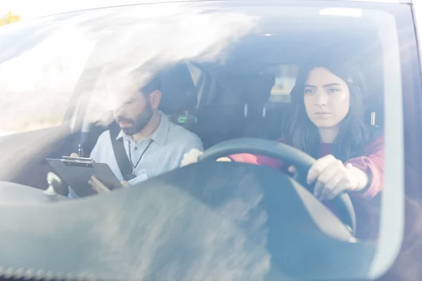 Carino Donna Concentrandosi Durante Guida Istruttore Auto Visto Attraverso Parabrezza — Foto Stock