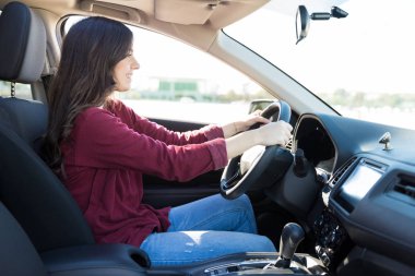 Onun araba sürüş ve gülümseyen sevimli genç esmer yan görünüm