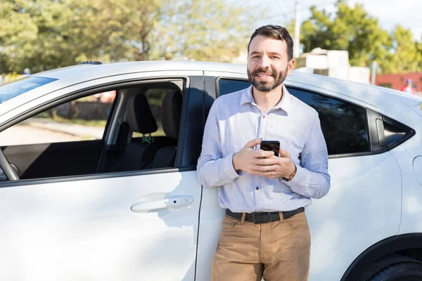 Bonito Homem Latino Sorrindo Enquanto Segurava Telefone Celular Perto Carro — Fotografia de Stock