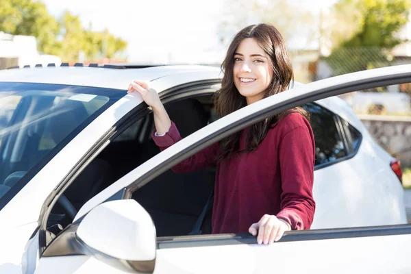 屈託のない若い女性に彼女の新しい車になってながら笑顔 — ストック写真