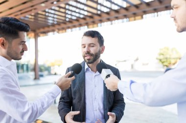 Muhabirin mikrofonlar basın toplantısında konuşan Latin erkek Ceo