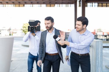 Gazeteci ve kameraman röportaj Kampüsü için yetişkin iş adamı reddetme