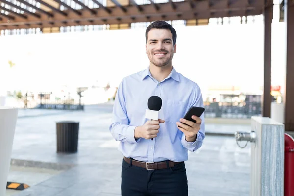 Portrait Smiling Young Male Reporter Holding Microphone Mobile Phone Broadcast — Stock Photo, Image