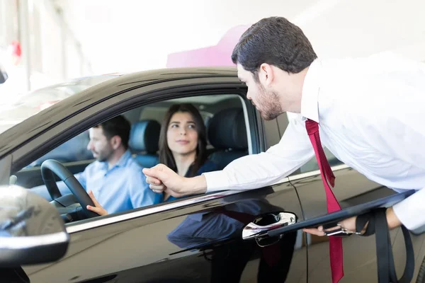 Seriöser Händler Betrachtet Paar Das Auto Sitzt Auto Merkmale Autohaus — Stockfoto