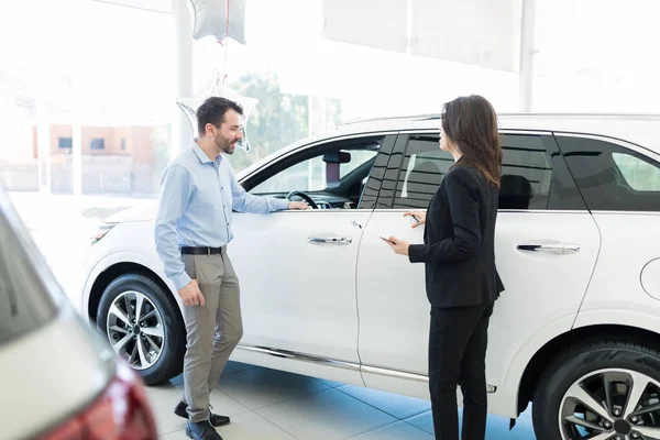 Curious Mid Adult Client Looking New Car Model While Saleswoman — Stock Photo, Image