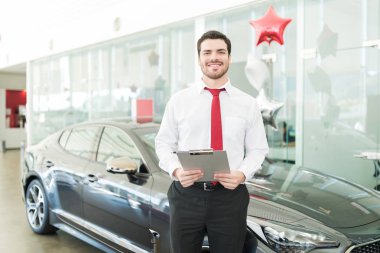 Orta yetişkin profesyonel satıcı Pano duran yeni araba ile tutarak