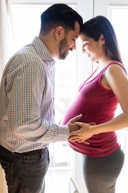 Yakında-to-be baba ve annenin evde birlikte vakit yan görünüm