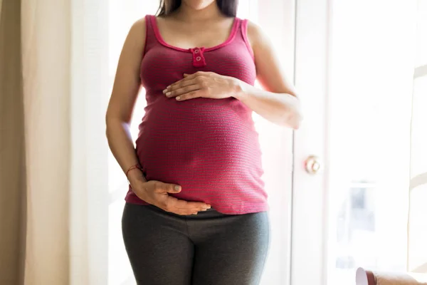 Midsection Mulher Expectante Tocando Barriga Para Sentir Movimento Fetal Casa — Fotografia de Stock