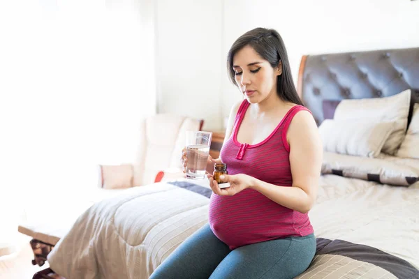 Dobra Kobieta Szuka Przyjmowania Leków Ciąży Siedząc Łóżku — Zdjęcie stockowe