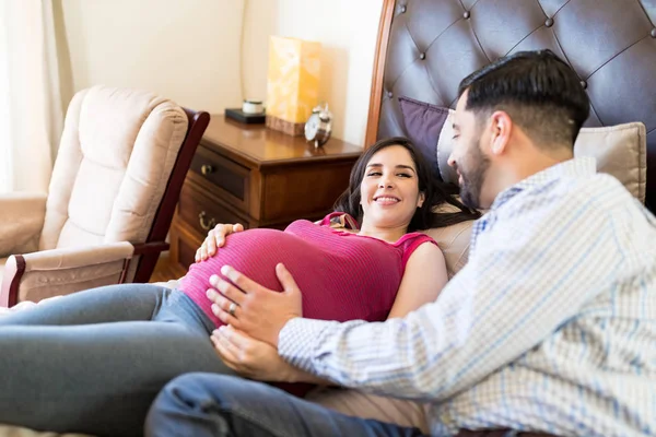 Uśmiechający Się Łaciński Kobieta Ciąży Patrząc Męża Sypialni Domu — Zdjęcie stockowe