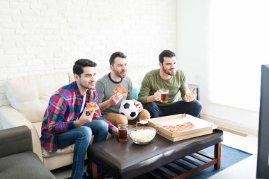 Üç adam televizyon ve sahip Pizza evde bira ile maç futbol izlerken