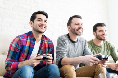 İspanyol erkekler birlikte oturan, evde video oyunu oynayan gülümseyen