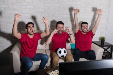 Neşeli fanlar evde TV de maç futbol izlerken çığlık