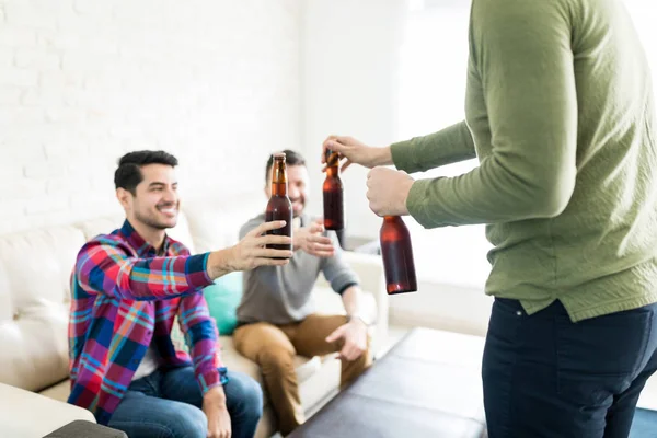 Молодой Человек Подает Пиво Бутылки Друзьям Гостиной — стоковое фото