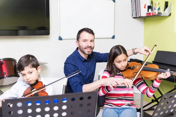 自信を持って家庭教師音楽レッスンでヴァイオリンを演奏する学校の生徒指導 — ストック写真